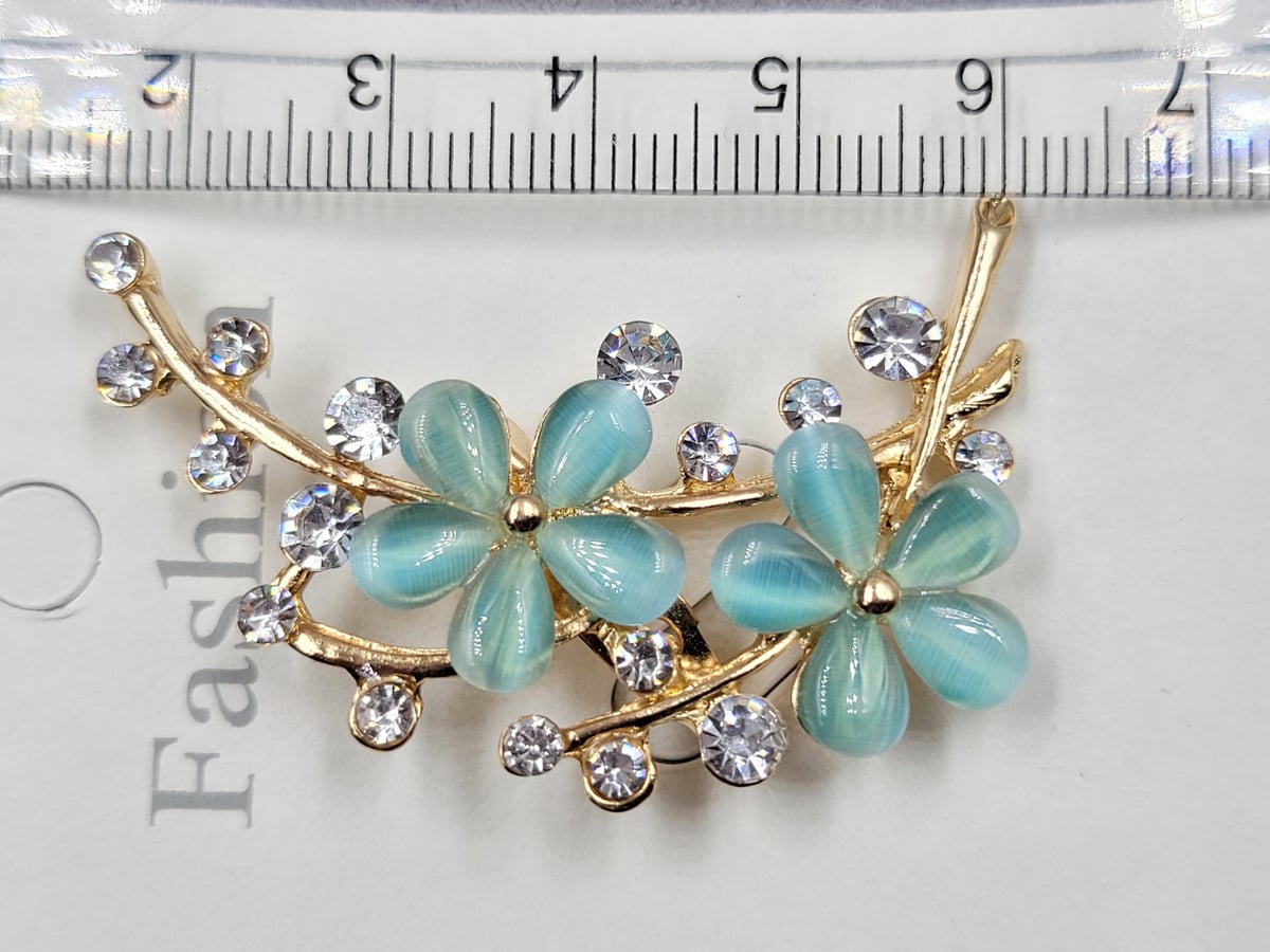 Брошь з голубим кішковим оком